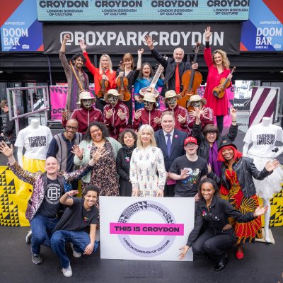 Photo of the launch of This is Croydon at Croydon Box Park. Members of the delivery team with artists in front of a This is Croydon sign.