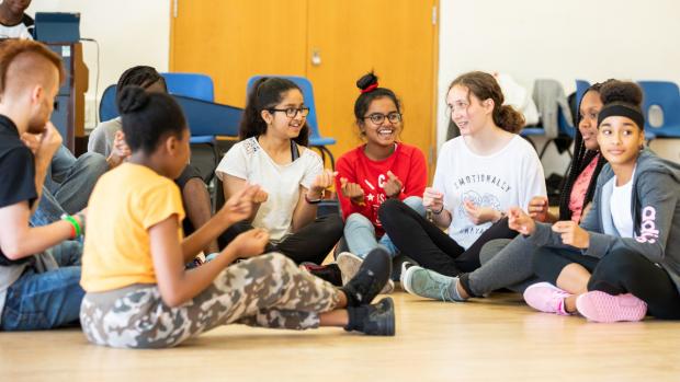 Croydon Young Composers. A group of young people sitting on the flow clicking their fingers.