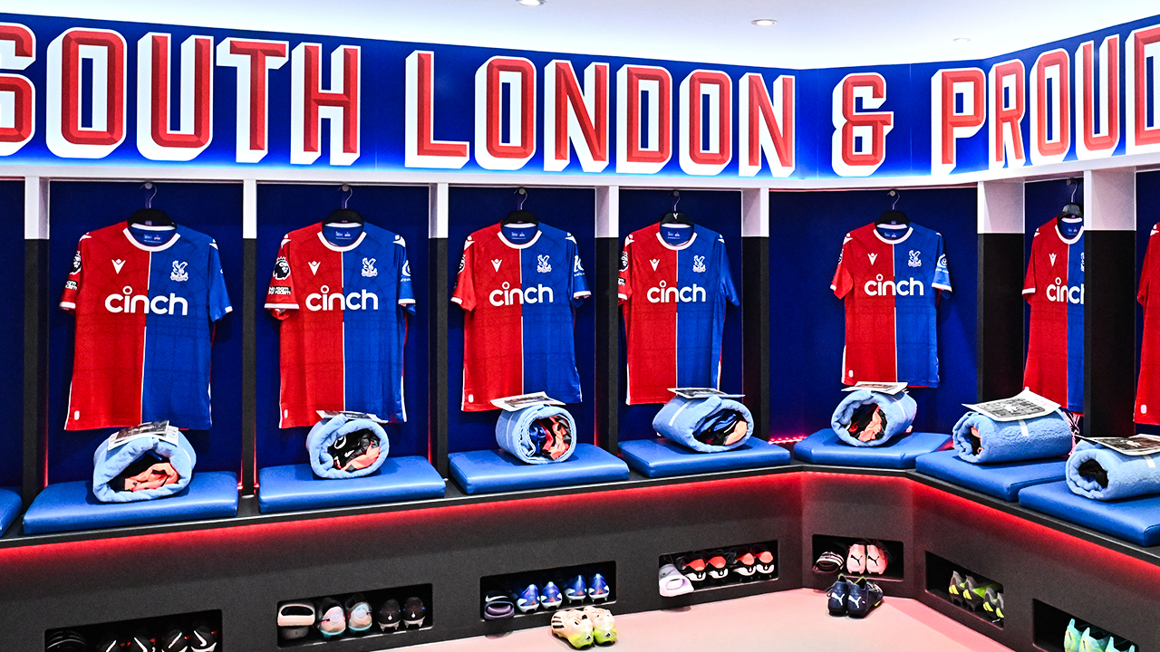 Photo of Crystal Palace FC changing room. Kit in home colours with a banner above saying South London & Proud