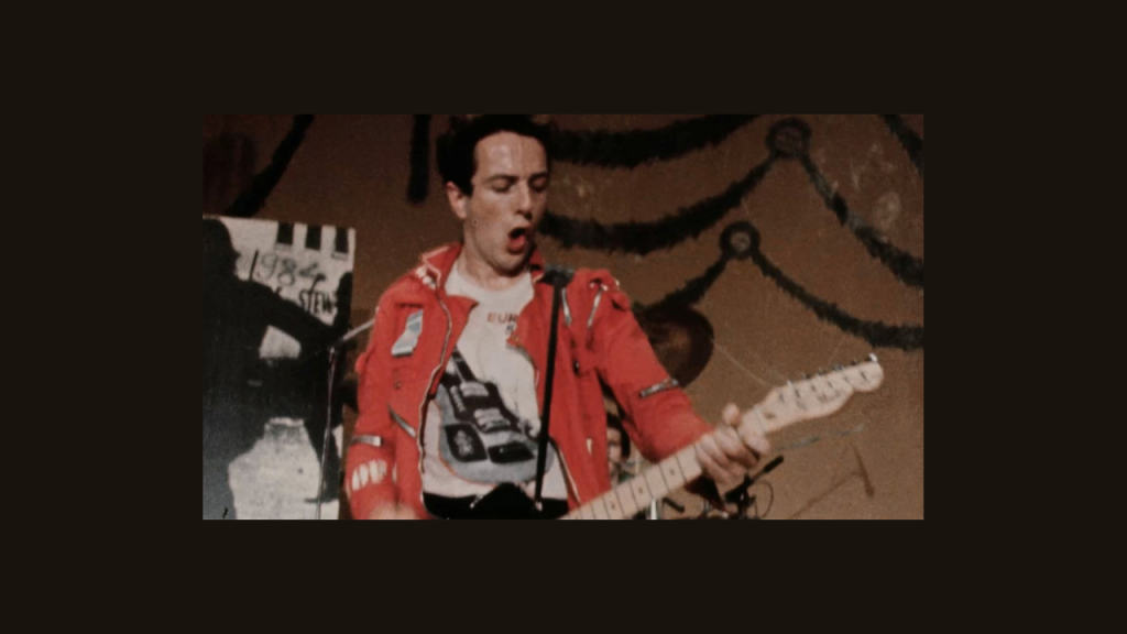 Photo from Punk in London. A man playing guitar. 