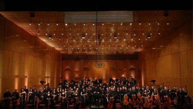 Photo of the Symphony Orchestra of India on a concert hall platform.