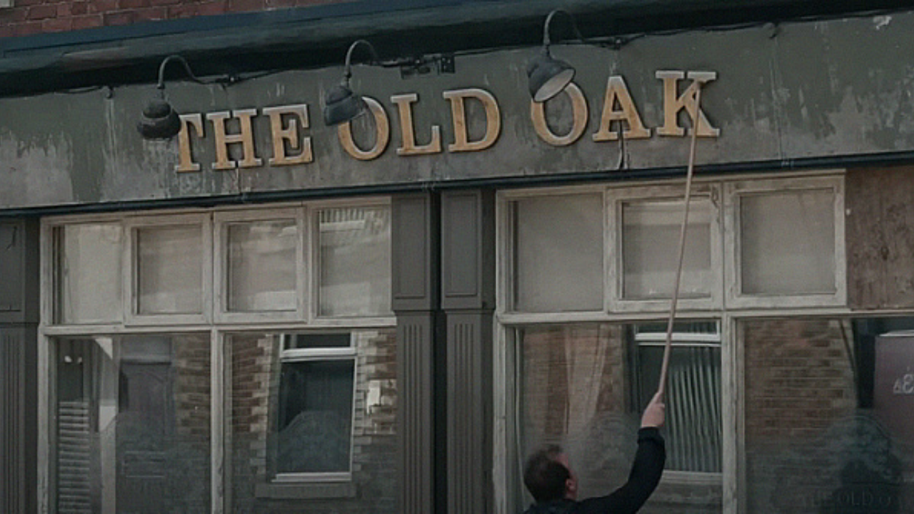 Photo of The Old Oak pub front with a man cleaning.