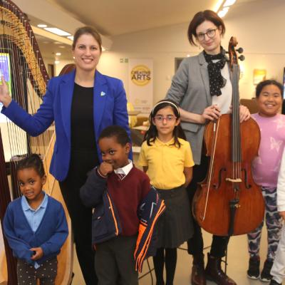 Photo of members of Fairfield Halls' Yamaha Music School with the harpist and cellist from the National Symphony Orchestra of Ukraine for a pre-concert workshop in the foyer of Fairfield Halls