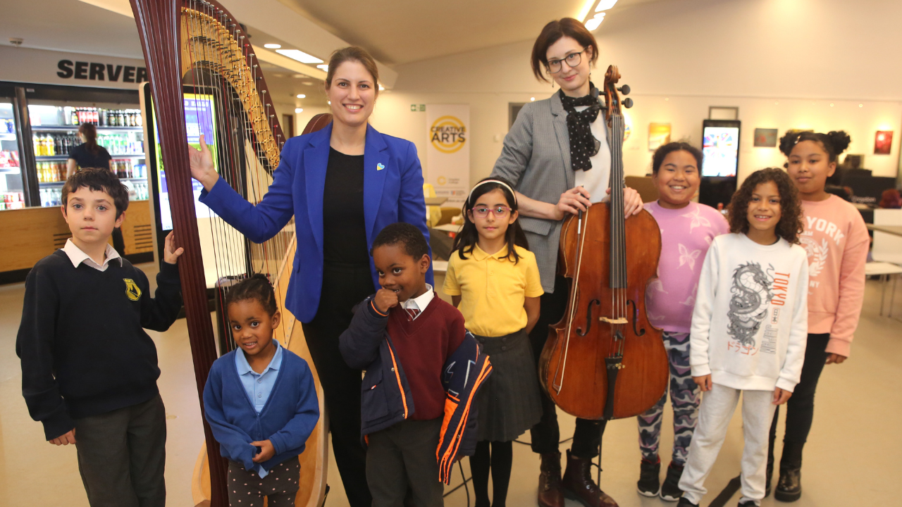 Photo of members of Fairfield Halls' Yamaha Music School with the harpist and cellist from the National Symphony Orchestra of Ukraine for a pre-concert workshop in the foyer of Fairfield Halls