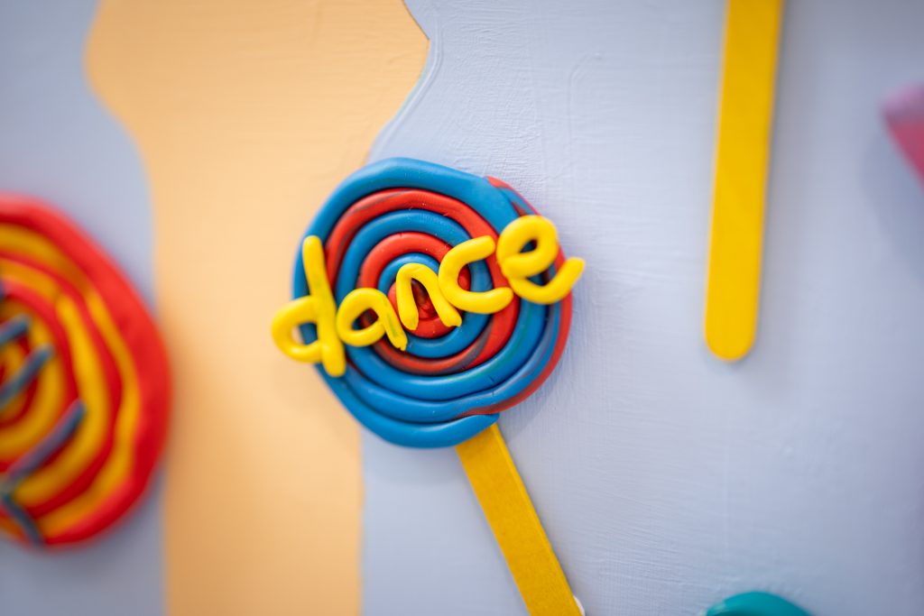 A colourful lollipop with the word 'dance' written in yellow