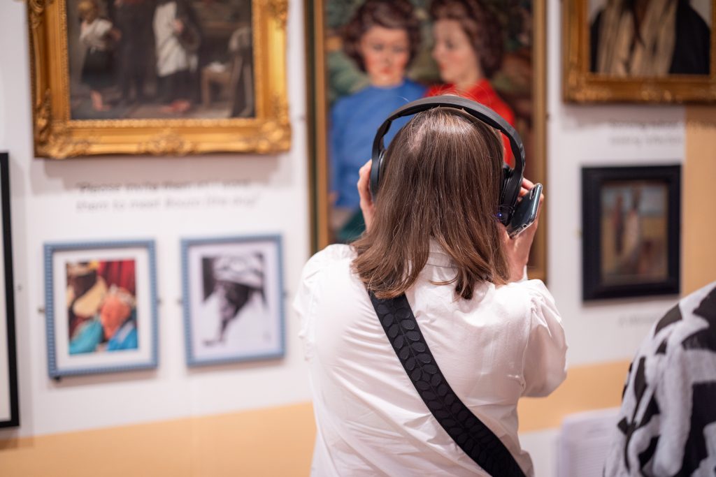 A person listening to headphones while looking at artworks