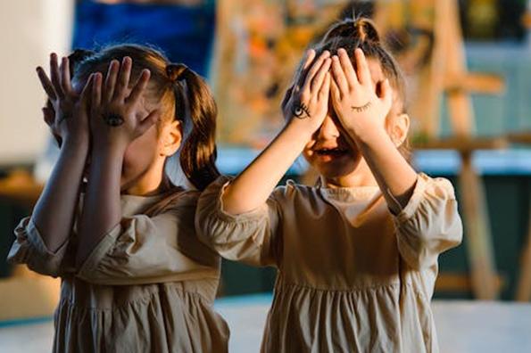two girls covering their faces