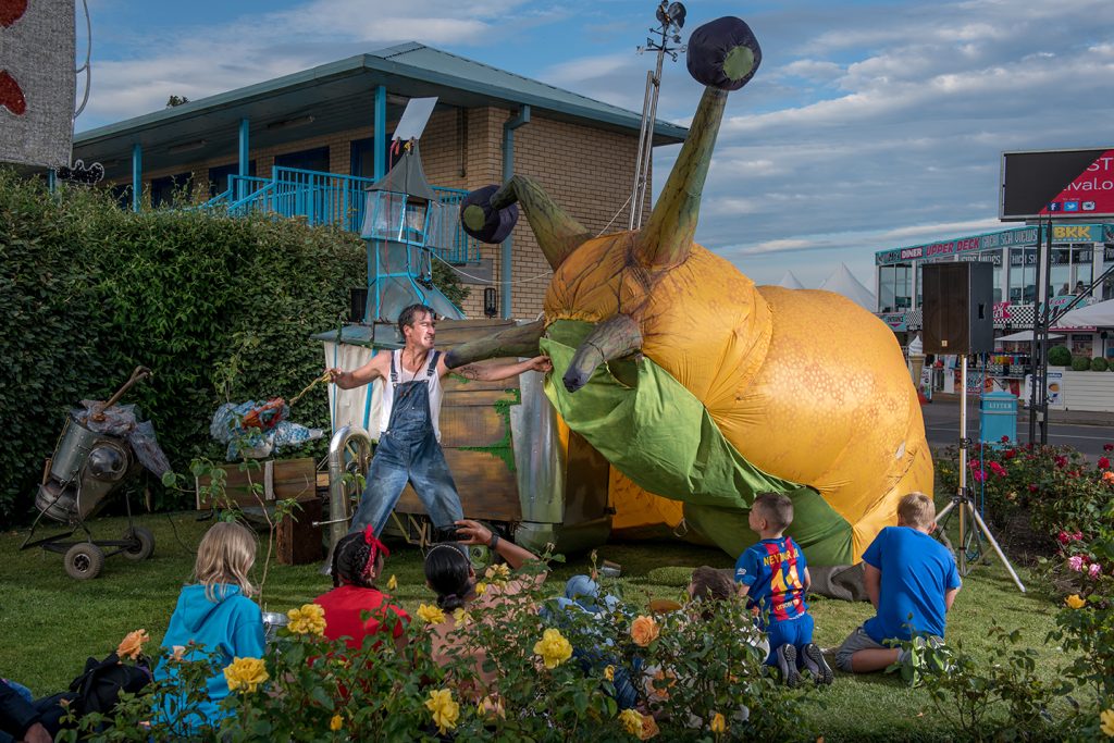 An actor with a giant slug puppet