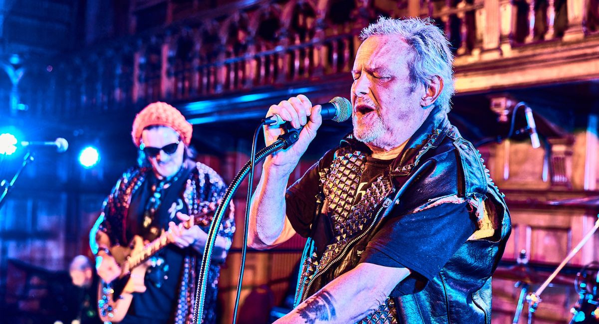 A man singing into a microphone in Croydon's Braithwaite Hall