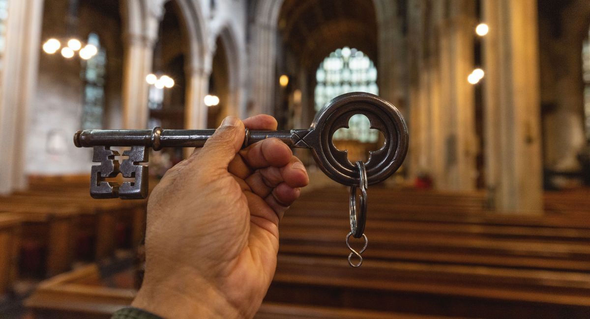 A hand holding up a giant key inside Croydon Minster