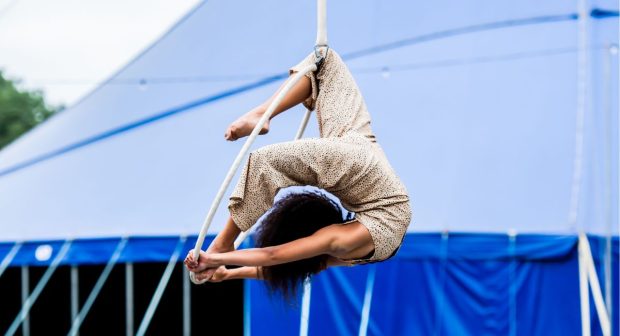 A aerial circus artist poses in the air