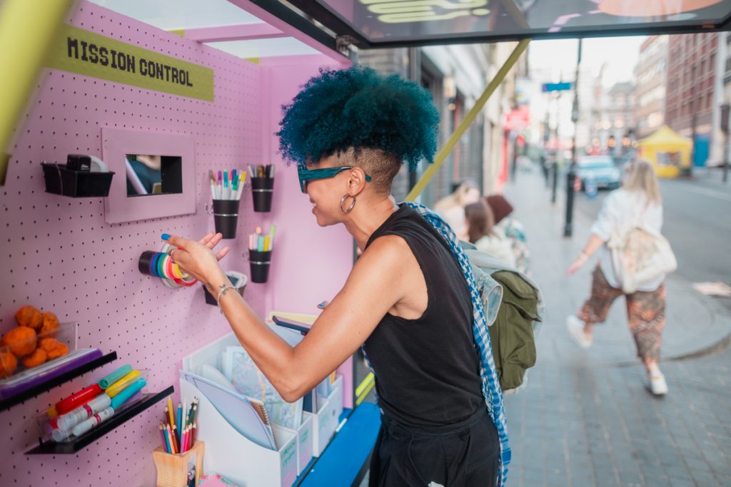 A lady with blue hair selects art materials