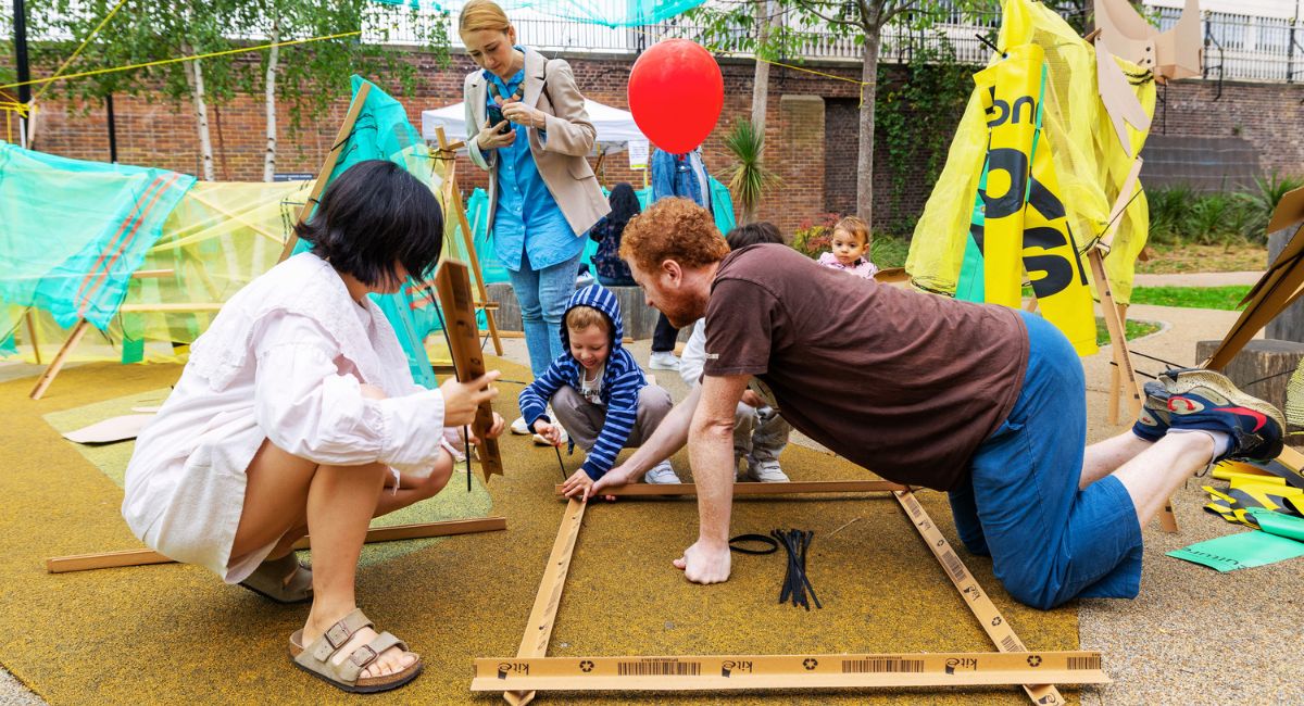 A family construct a den out of recycled materials